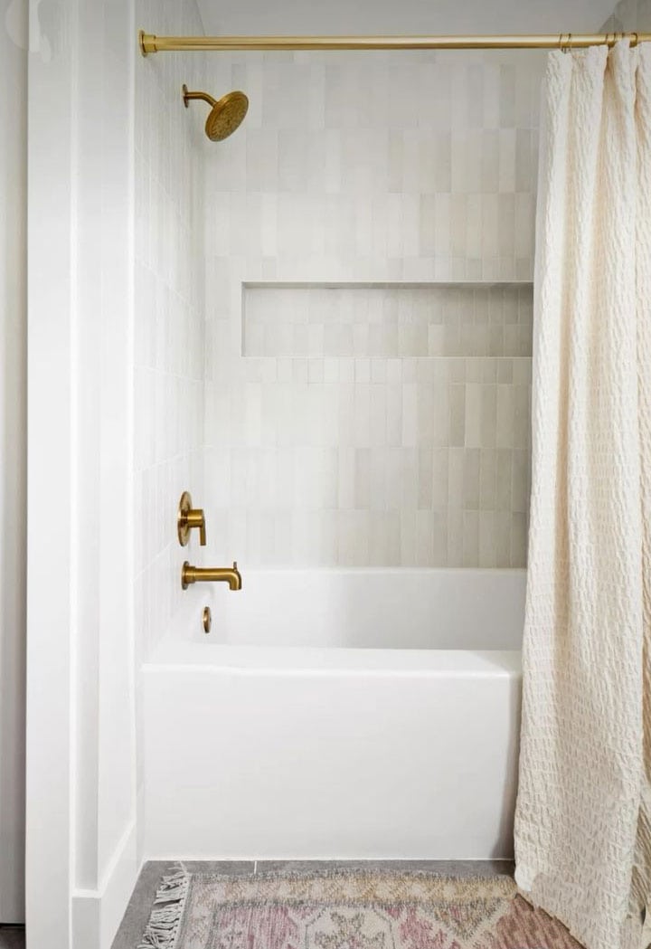 neutral-tile-in-bathtub-shower-combo-with-brass-fixtures